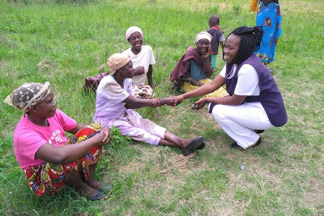 Nurse Carole saluting women during a community outreach, Zambia